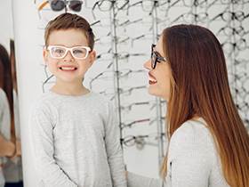 Mother with cute son. Family buy glasses